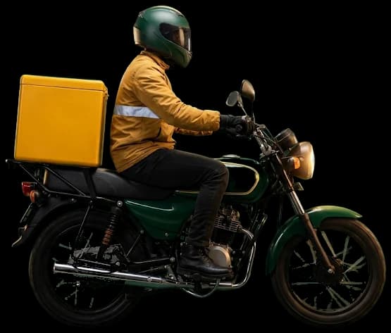 A 10th Gear rider in a yellow jacket and green helmet on a green delivery motorbike with a yellow delivery box, riding through Lagos at night